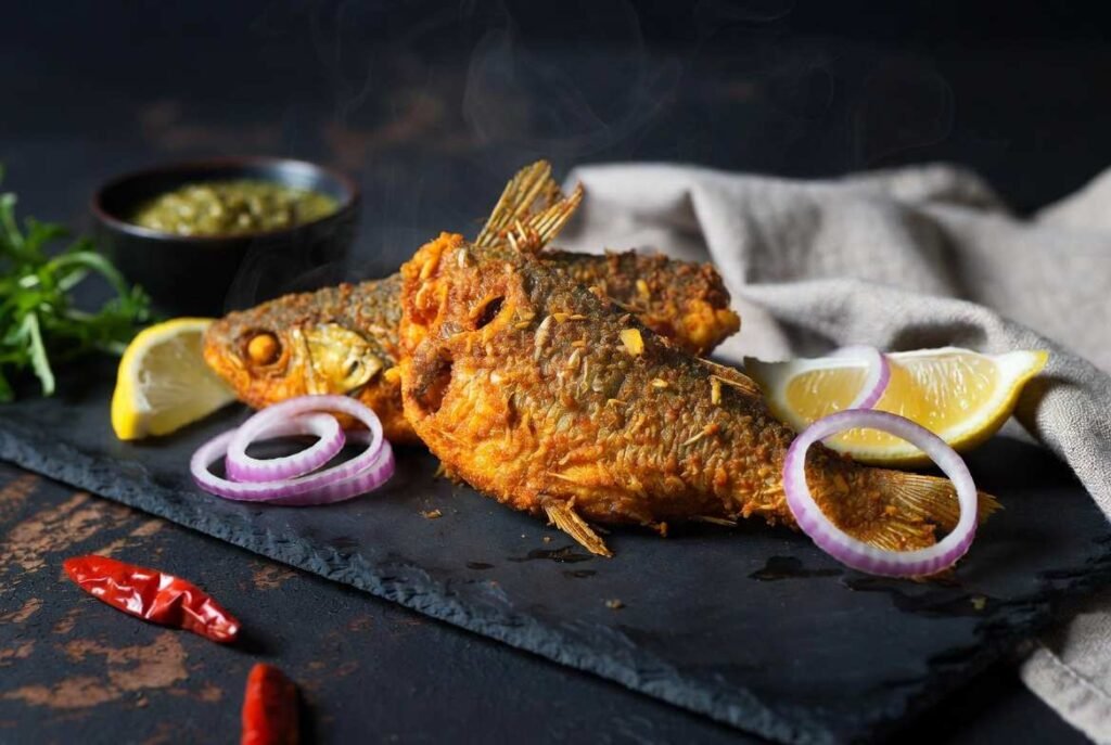 Crispy fried rohu fish fry recipe with onion rings and green chutney garnish